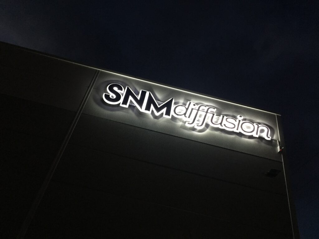 SNM Diffusion - enseigne rétroéclairée vue de nuit